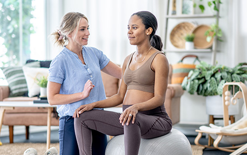 Pregnant woman at home with an Occupational Therapist assisting her